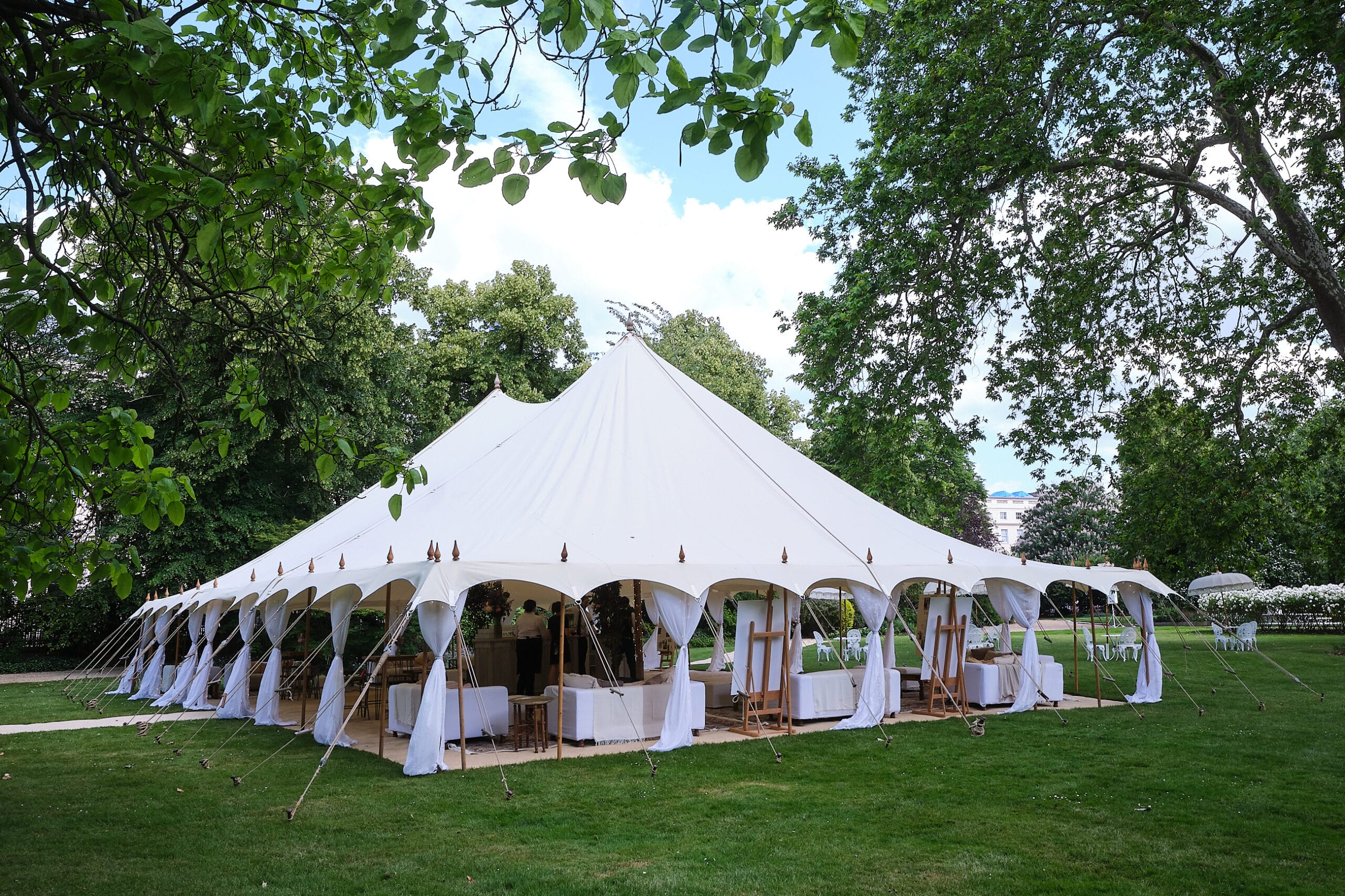 A pole marquee set in parkland
